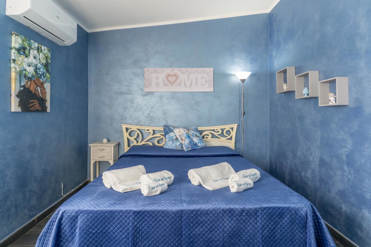 Camera Stella: letto matrimoniale con la testata in ferro battuto e le pareti blu